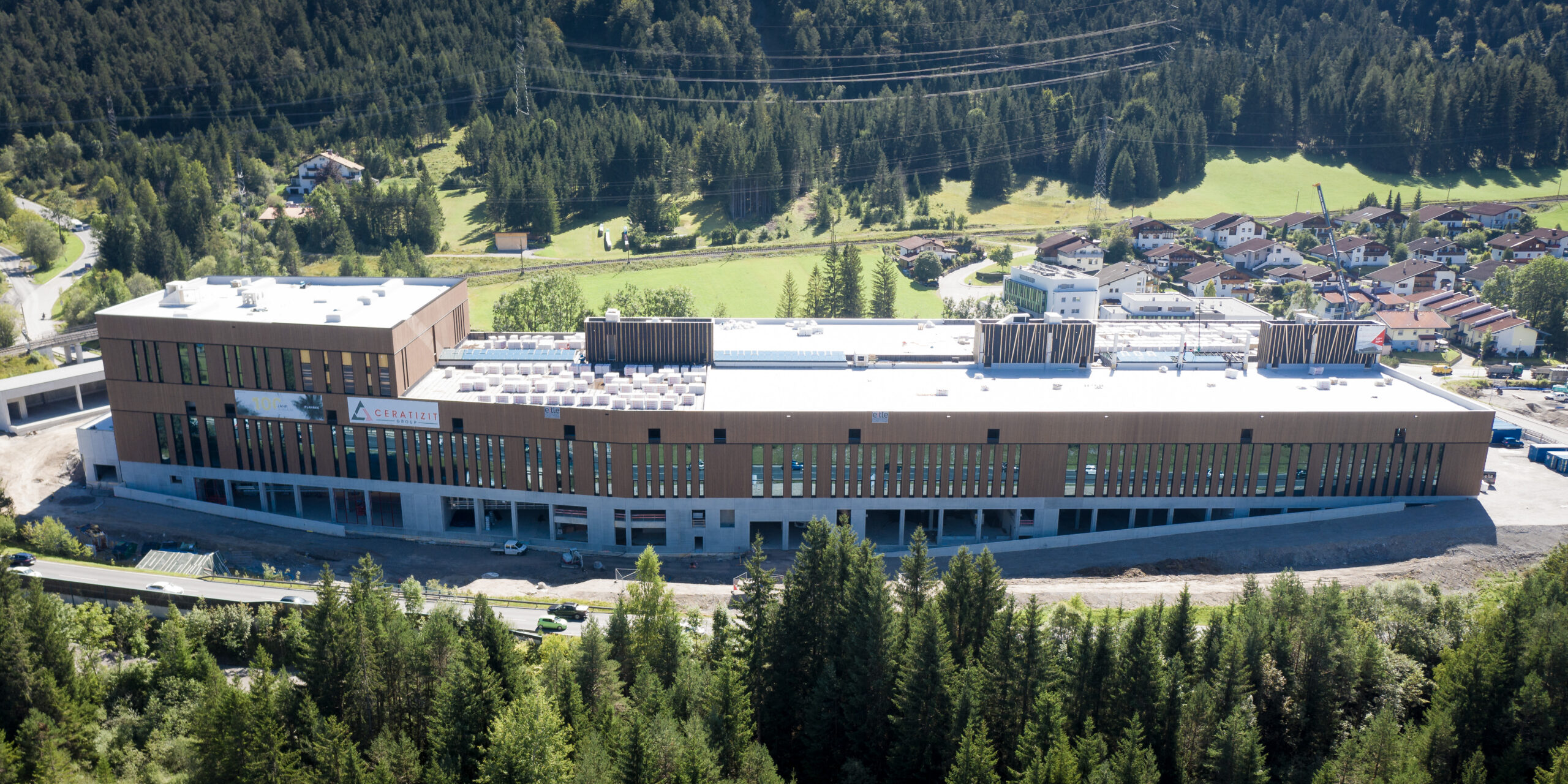 Referenz Holzbau Saurer Gewerbe- und Industriebauten aus Holz Produktionsgebäude Ceratizit Kreckelmoos Luftaufnahme Tagesaufnahme Landschaftsverbunden harmonisch eingebettet