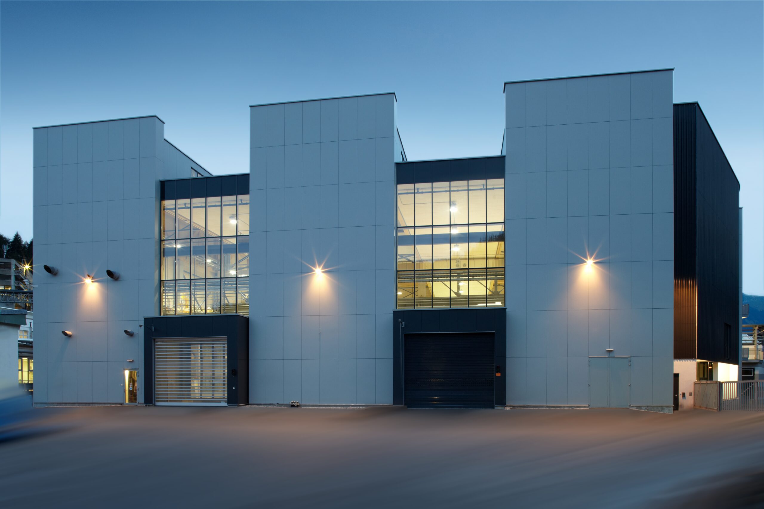 Produktionshalle Oberflächentechnik ästhetischer Holzarchitektur technische Funktionalität Nachtaufnahme Verglasung