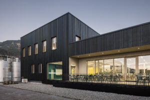 Referenz Holzbau Saurer Aufstockung Bürogebäude Rauch Seitenansicht Terrasse Fassade kombiniert aus Meltallpaneelen und Holzverkleidung