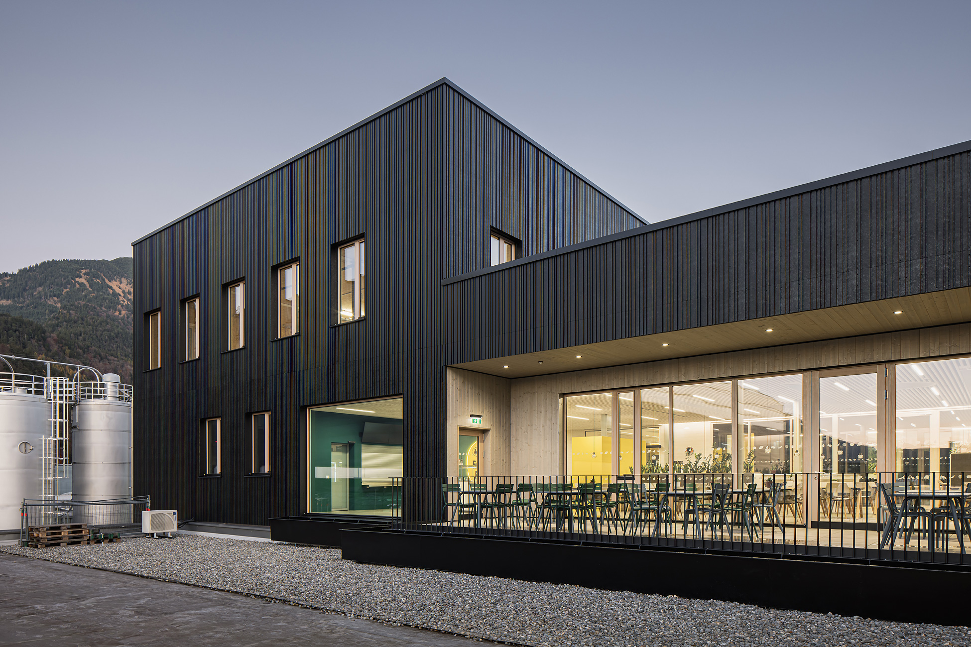 Referenz Holzbau Saurer Aufstockung Bürogebäude Rauch Seitenansicht Terrasse Fassade kombiniert aus Meltallpaneelen und Holzverkleidung