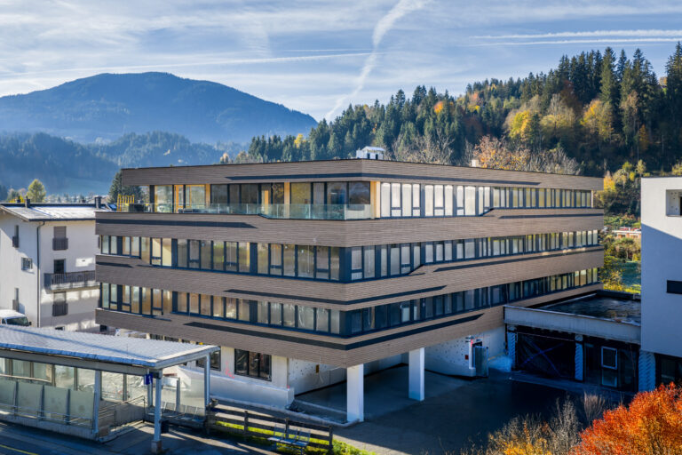 Referenz Holzbau Saurer Gewerbebau Bürogebäude Pletzer Tagesaufnahme eingebetet in Landschaft Herbst