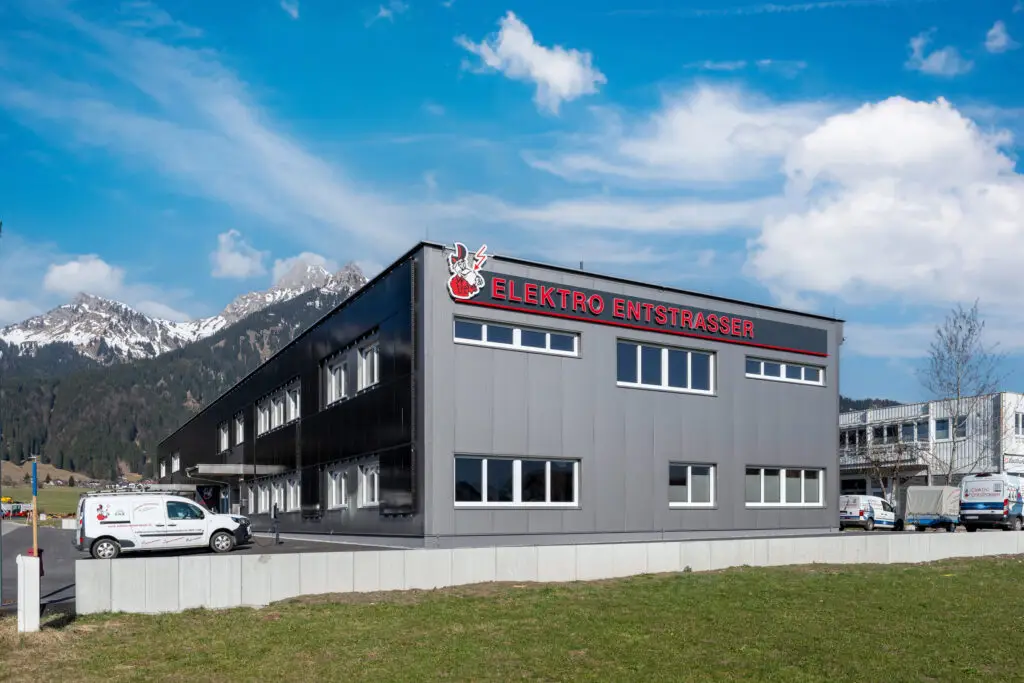 Referenz Holzbau Saurer Elektro Entstrasser modernes Betriebsgebäude mit klarer Grundrissgestaltung Außenansicht seitlich