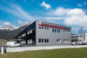 Referenz Holzbau Saurer Elektro Entstrasser modernes Betriebsgebäude mit klarer Grundrissgestaltung Außenansicht seitlich